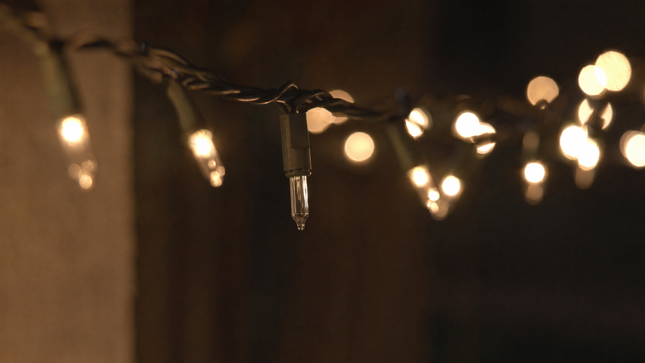 String of warm white fairy lights with one bulb visibly dark and unlit among the glowing bulbs
