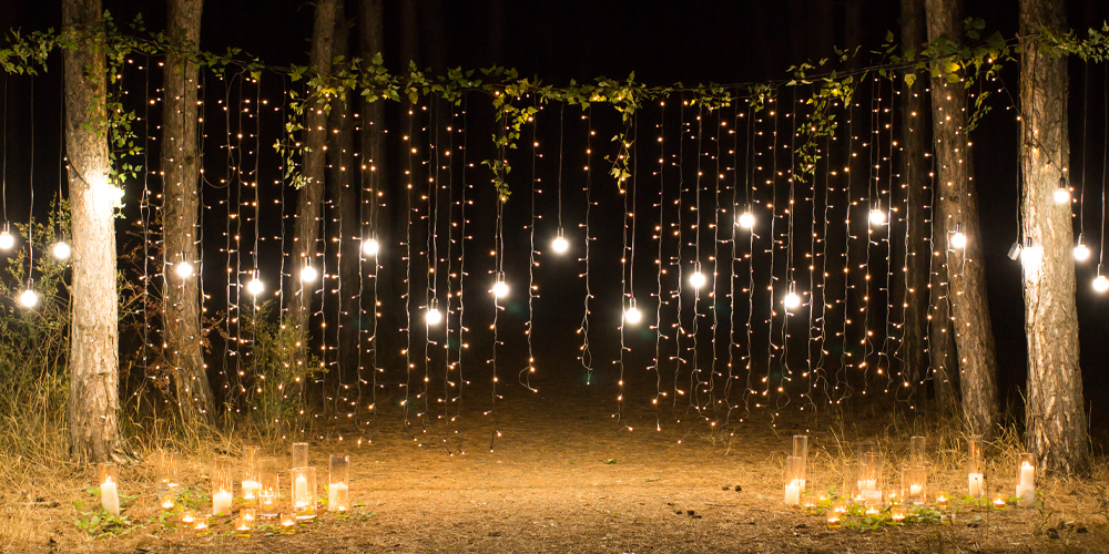 outdoor space decorated with string lights and candles 